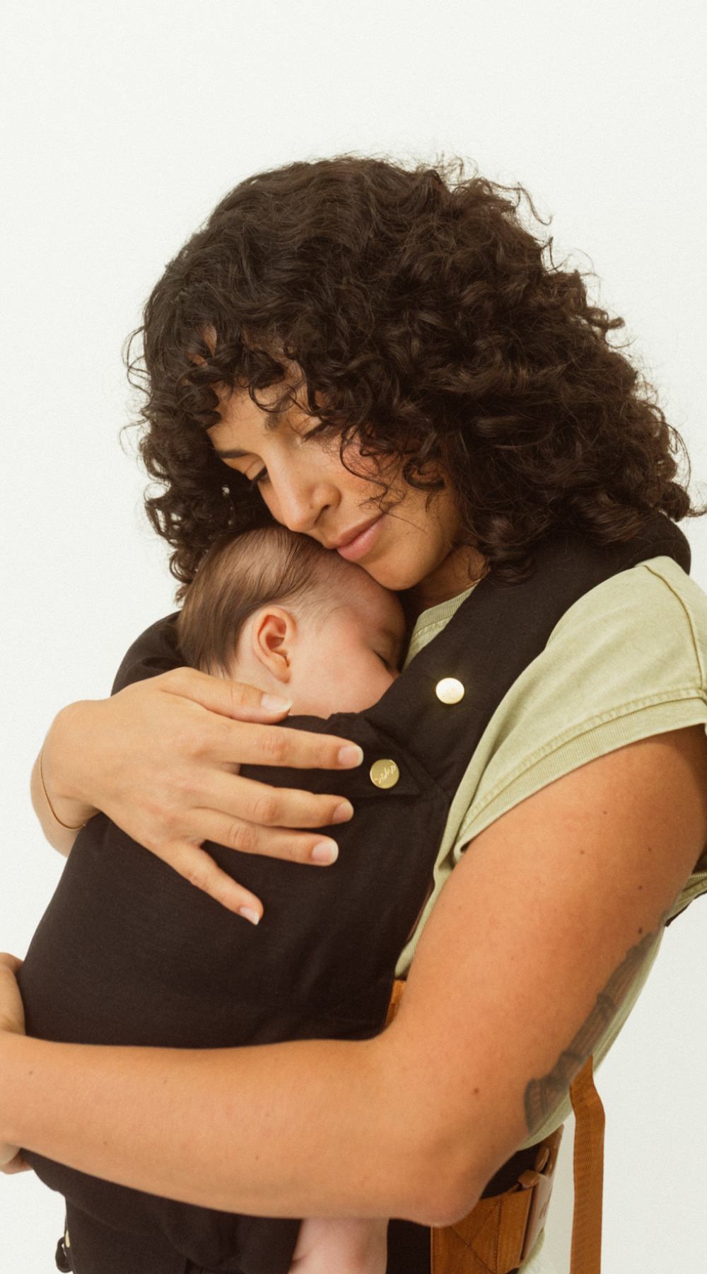 Close up details of the Jett Black Clip Carrier 2.0 as mum cuddles her baby close as they embrace in the Chekoh Baby Carrier. Designed for maximum babywearing comfort and support.