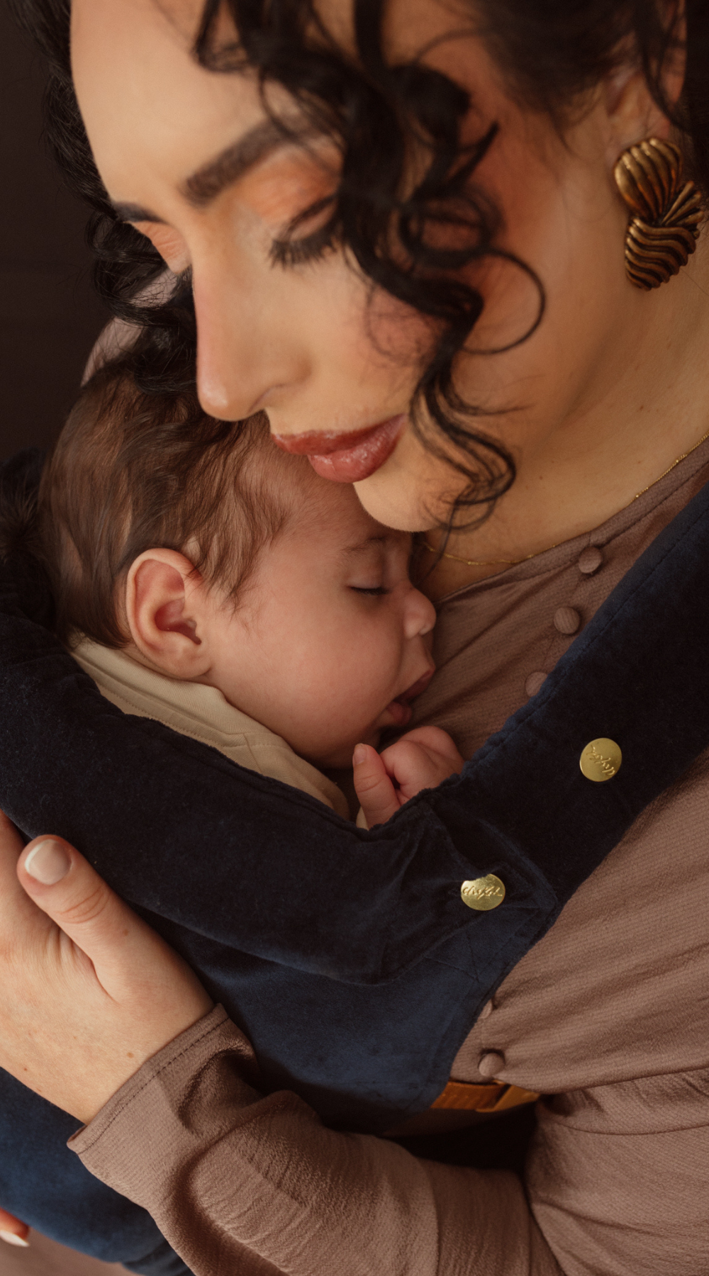 Close up image of mother and baby embracing cuddles with their Chekoh Baby Luna Velvet Clip Carrier. Baby is sleeping comfortably and Mum has the ability to do anything handsfree.